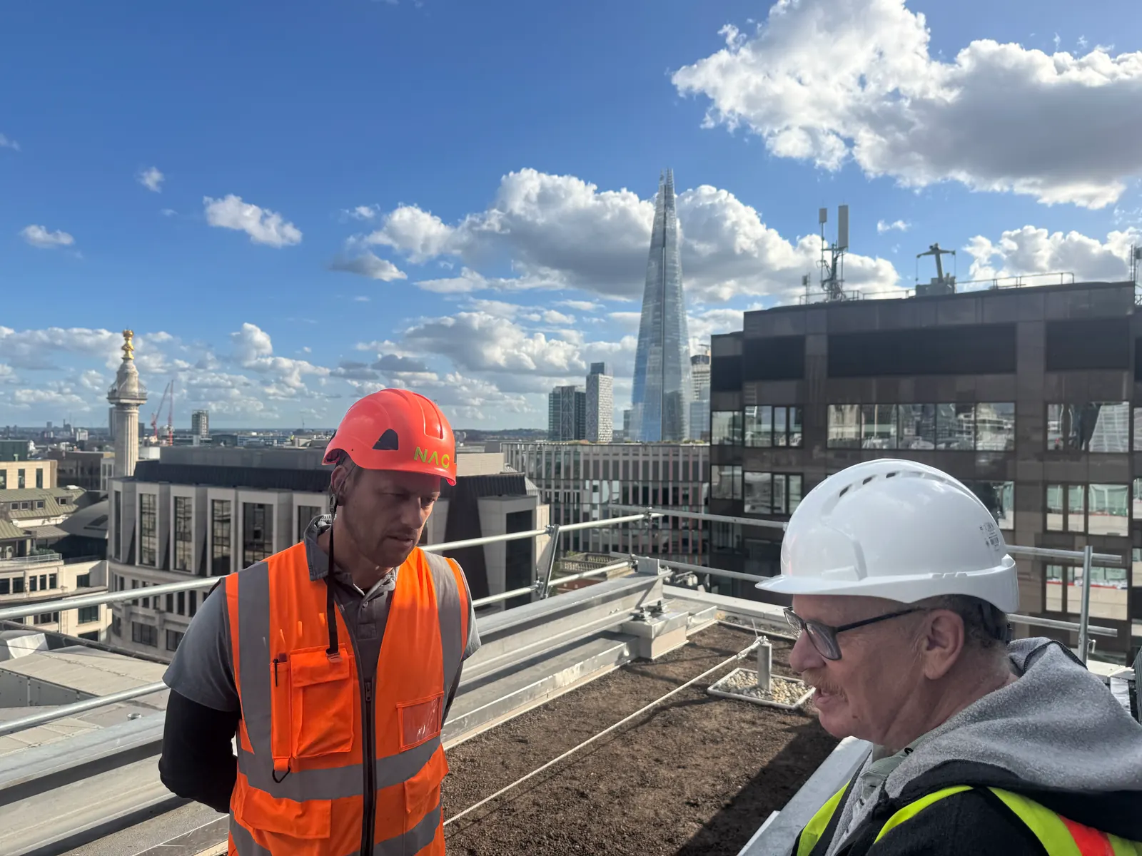 HPL assessor talking with a candidate on a London rooftop site, the Shard behind
